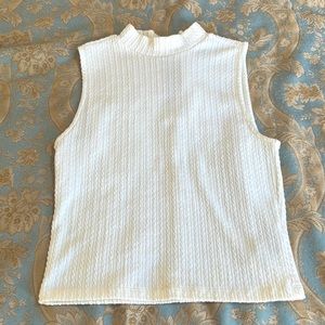Chic white ribbed mock neck sleeveless top with gold zipper back!